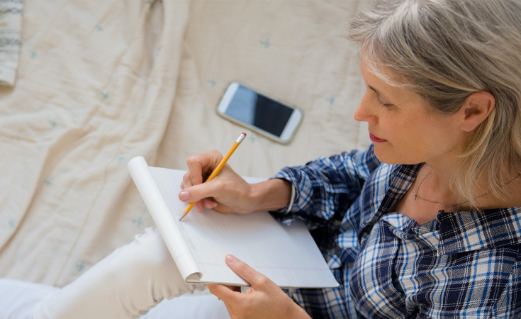 older woman writing on a piece of paper