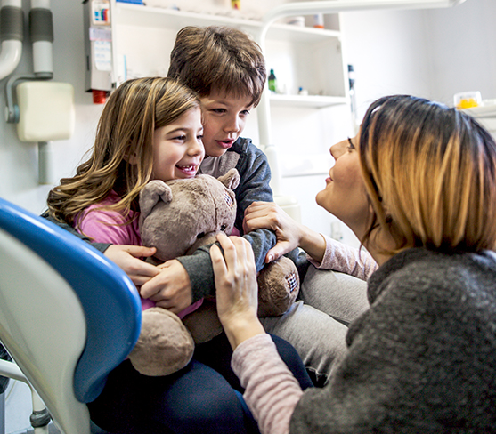 Children hugging in dental office
