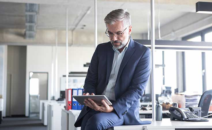 Man in a suit sitting on a desk