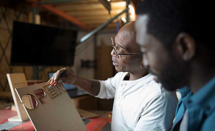 Two men looking at an open sign
