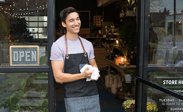 Man smiling in front of a store