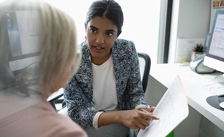 two business women discussing paperwork