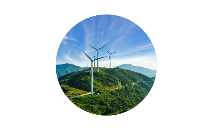 windmills forming a line along mountain tops amid a bright blue sky