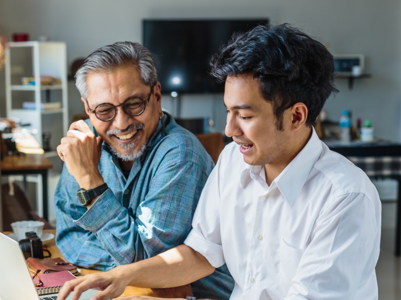 father and son sitting and smiling together