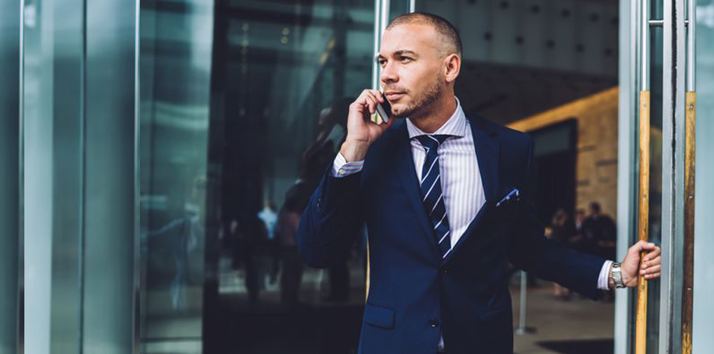 man talking on the phone while walking out the door