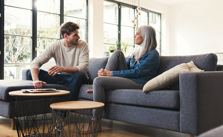 older woman and son sitting on the couch and talking