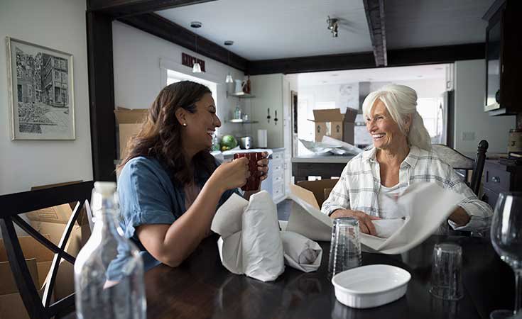 mother and daughter sitting at a table and smiling